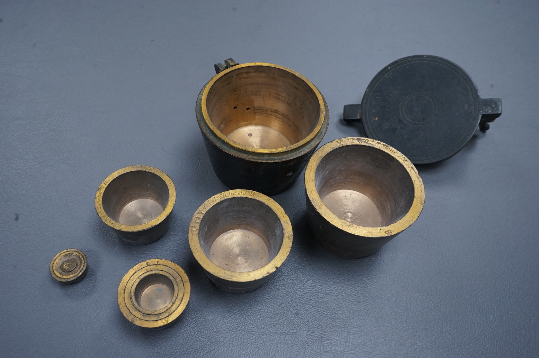 A 19th century brass nest of weights, the case with engraved inscription, 18 stone/4lb, Weeks’s Mechl. Museum, Tichborne St., 10cm wide